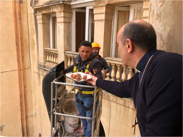 Il Vescovo di Ragusa offre frittelle di S.Martino dalla sua finestra agli operai al lavoro